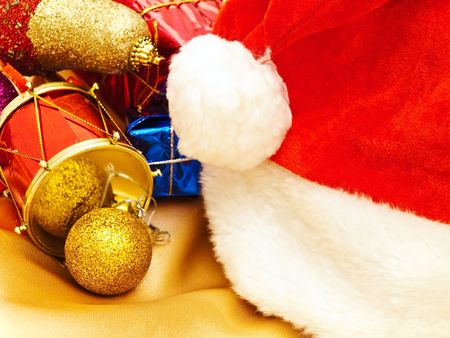 multicolored  christmas decorations with santa hat at the golden fabric draperyの写真素材