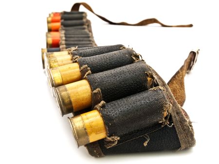 Photo of old cartridge in leather belt for hunting rifle against white backgroundの写真素材