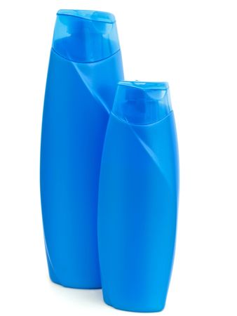 two plastic blue bottles of shampoo over whiteの写真素材