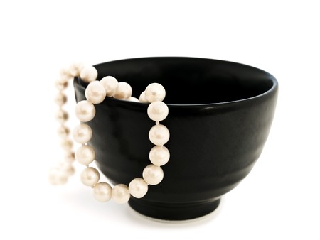 white pearl in black bowl over white backgroundの写真素材