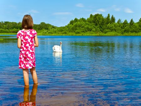 girl and white swan at blue lakeの写真素材