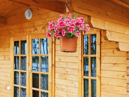 flower pot dangling from the roof of the houseの写真素材