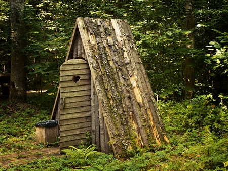 wooden toilet with opened door in the forestの写真素材