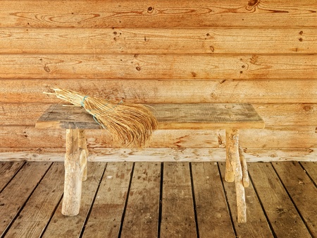 bench and  broom over it against wooden wallの写真素材
