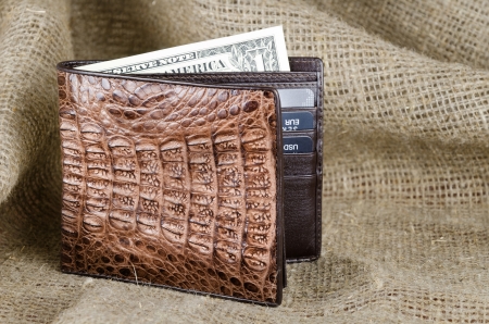 Wallet made of genuine crocodile leather over the linen backgroundの写真素材