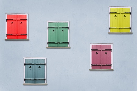 closed windows with colorful shutters in the blue house wall の写真素材