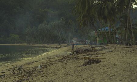 Communal fishing with a net where many villagers pull out the net together seen at dirty beach in West Sumatraの写真素材