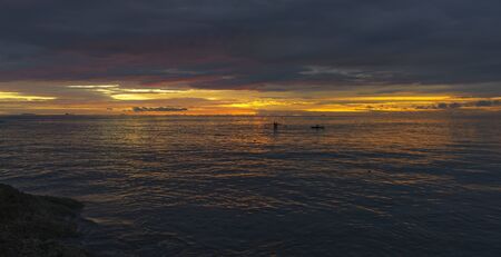 Beautiful sunset in the evening and local fishermen fishing from boats in indian ocean near Padang, Sumatraの写真素材