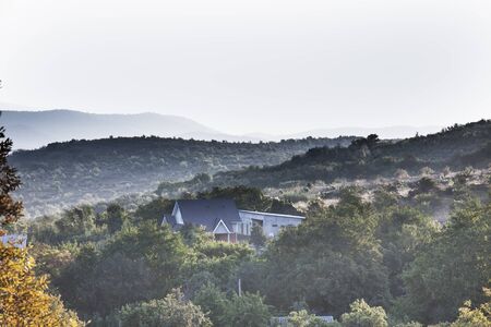 sunlight illuminates the mist on the field in the mountains in the early morningの写真素材