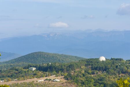 view of a small Observatory on the background of the steep mountain slopesの写真素材