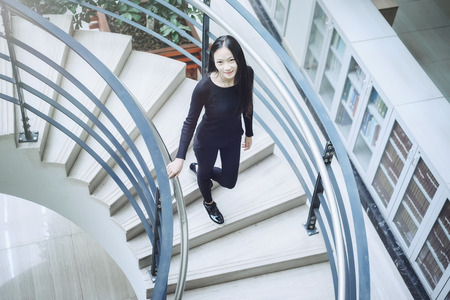Top view of a woman walking down spiral stairsの写真素材