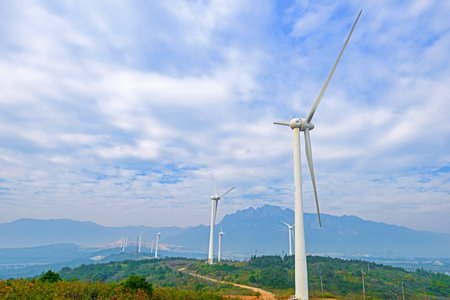 rotating wind turbine in front of cloudy sky