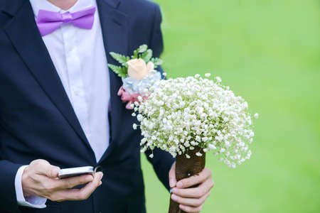 wedding bouquet with white flowers in the hands of the groomの写真素材