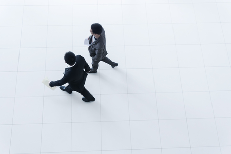 Two business people walking, high angleの写真素材