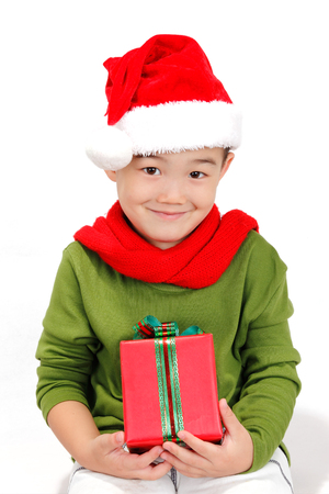 Boy holding a Christmas gift isolated on white backgroundの写真素材