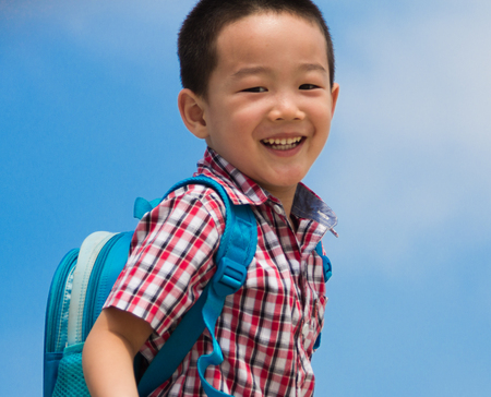 Happy Chinese teenager, carrying satchel on the back to schoolの写真素材