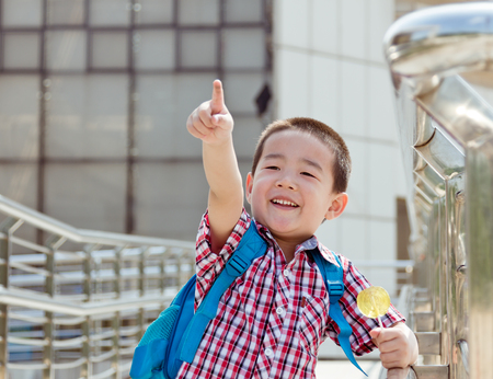 Happy Chinese teenager, carrying satchel on the back to schoolの写真素材