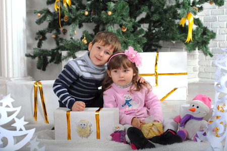Boy and girl with gifts for Christmas. Happiness and thoughtfulness on children\\のeditorial素材
