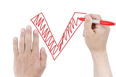 Hand draws check mark on white paper.の写真素材