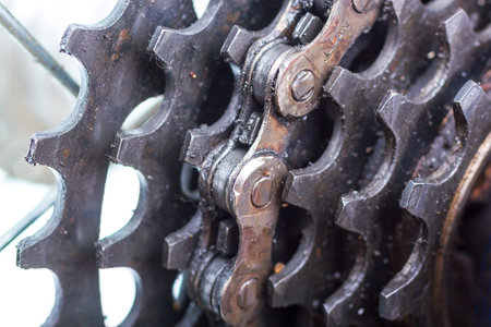 Dusted bicycle rear sprockets with chain on, close up.