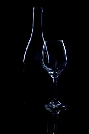 Silhouette of wine bottle and glass on black mirror.の写真素材