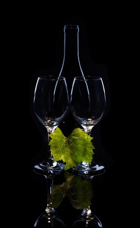 Silhouette of wine bottle and glass on black mirror.の写真素材