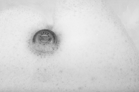Draining foam in a bathtab.の写真素材