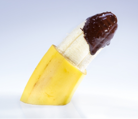 Dark chocolate dipped peeled banana, food porn concept.の写真素材