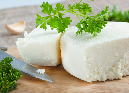 Cotija cheese with cilantro on cutting board .の写真素材