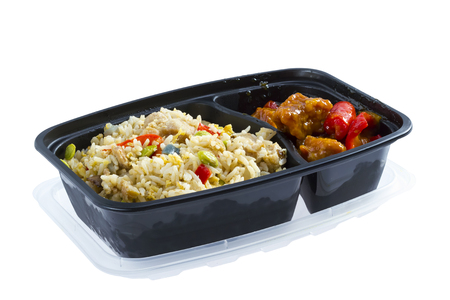Chicken rice and sour pork in black plastic lunch boxの写真素材