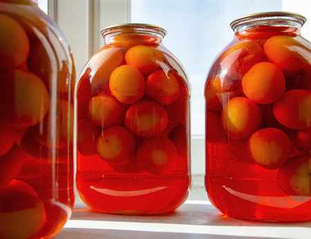 Compote from drains of scarlet color in jars in the sun on the windowsillの写真素材