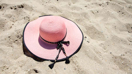 Sun hat at the beach. Pink sun hat on the sand at the beachの写真素材