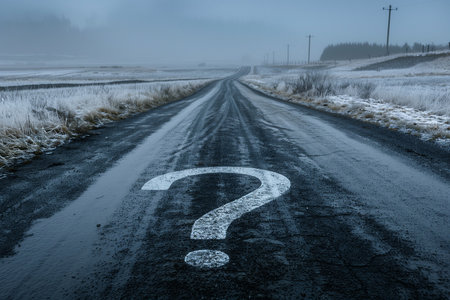 Conceptual image with question mark on the asphalt road in winterの素材
