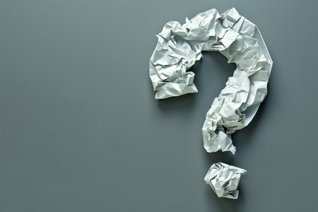 crumpled paper question mark on grey background top view mockupの素材
