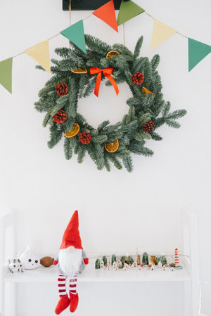 christmas wreath on white wall with toys and garland in roomの写真素材
