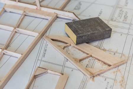 sanding of wood parts in construction of radio controlled model aircraft on instruction plane