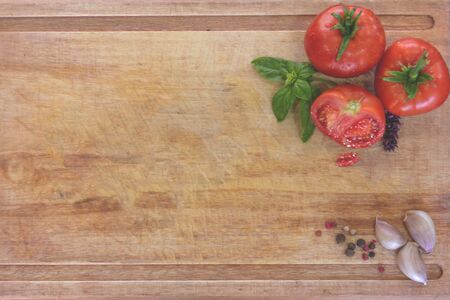 Tasty red tomatoes and chili on wooden boardの写真素材