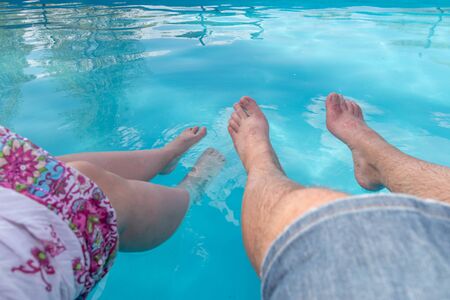 feet of woman and man in the waterの写真素材