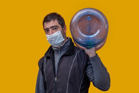 man in mask handing out water. Orange backgroundの写真素材