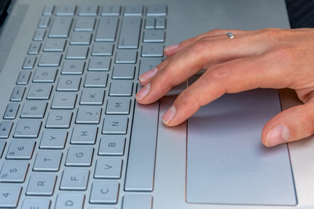 Hands of Hispanic woman typing on laptop