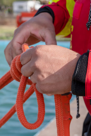 firefighter hands tying rope knot, vertical photo.