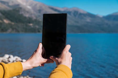 Girl photographing the lake on the tableの写真素材