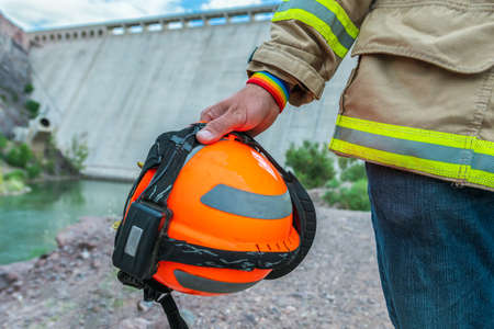 firefighter holding helmet, with LGBT bracelet.の写真素材