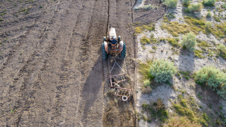 Top view of old tractor plowing. Aerial photo.