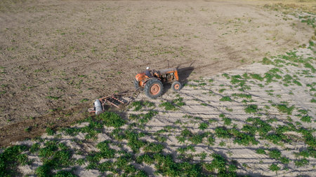 Top view of old tractor plowing. Aerial photo.