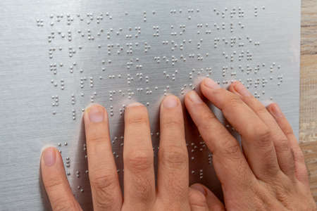 Close up of male hand reading braille textの写真素材