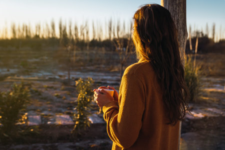 Latin woman drinking tea watching the sunset