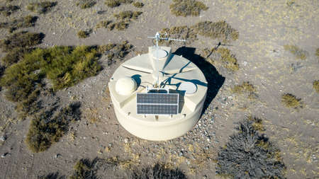 One of the detectors of the Pierre Auger observatory is seen close up with the Andes in the distance. The solar panel and antenna are clearly visible. In Malargue (Argentina)の写真素材