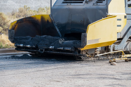 Asphalt paver machine working on a road construction site. Road repair.の写真素材