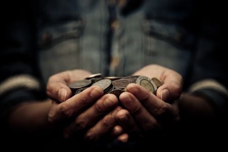 A coins in people hands in saving money conceptの写真素材